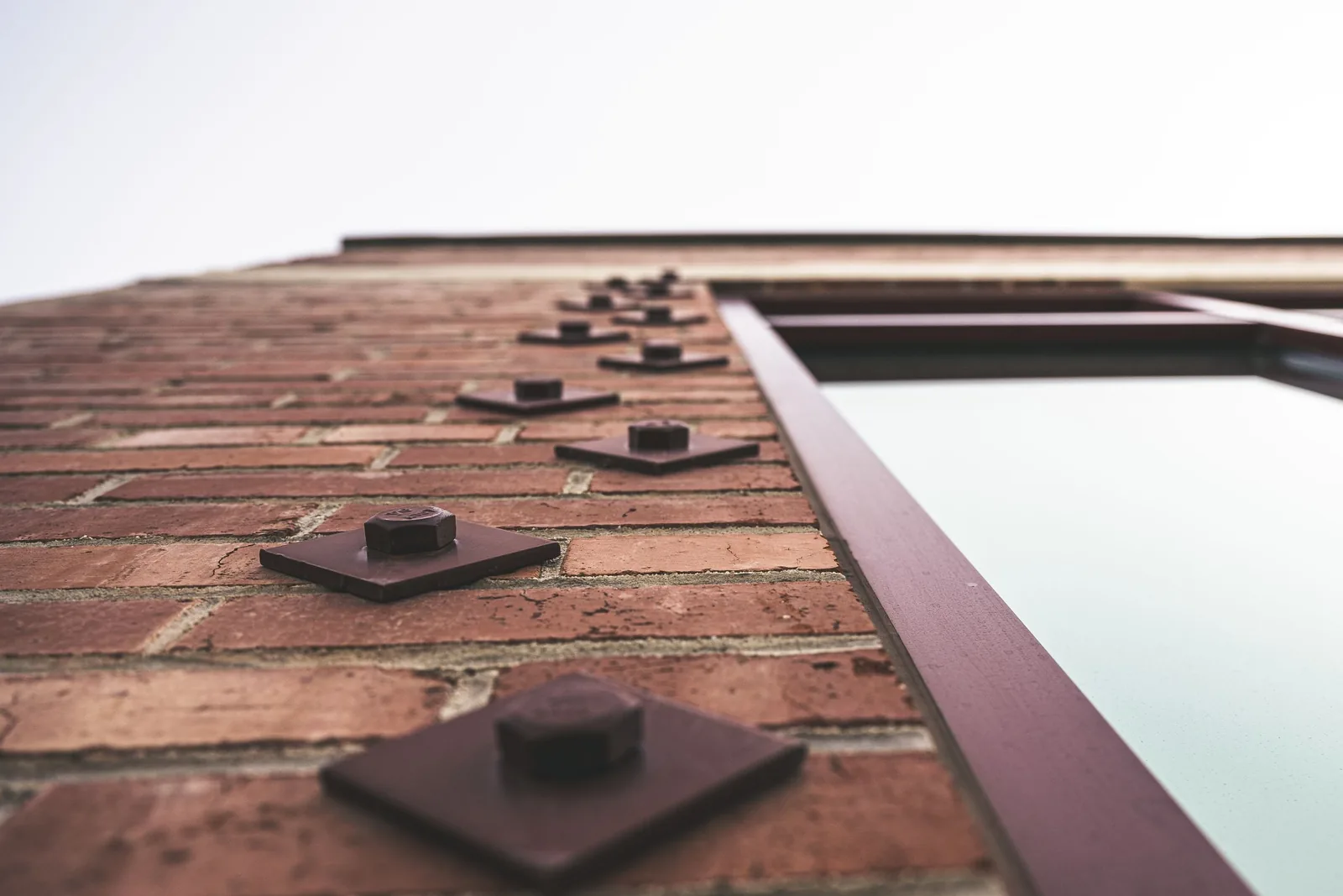Pormenor de uma fachada de edifício, com linhas e superfícies em tons claros